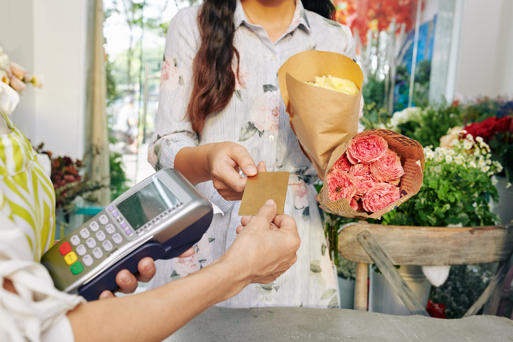 Young Woman Paying for Flowers